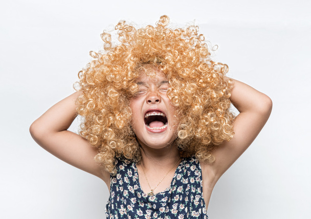 Wearing a blonde wig and funny facial expression Asian girl - Photo, Image