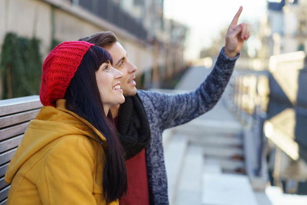 Young couple pointing up at an urban building - Foto, afbeelding