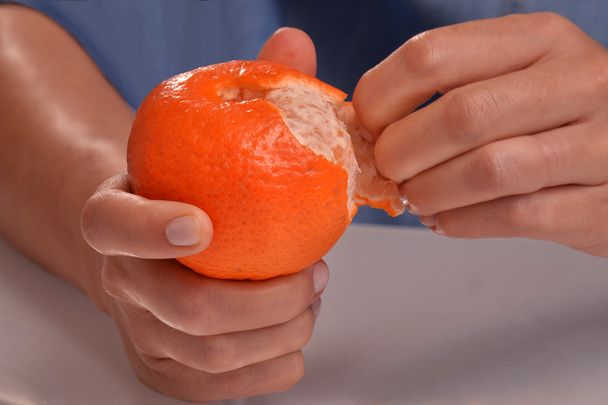 woman  peeling tangerine fruit. - Фото, зображення