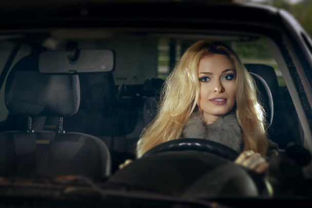 City portrait of pretty blonde driver inside the car. Night scen - Photo, Image