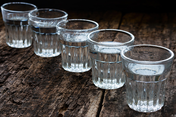 glasses of vodka on a wooden background - Foto, afbeelding