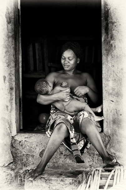 Benin woman feeds her child - 写真・画像