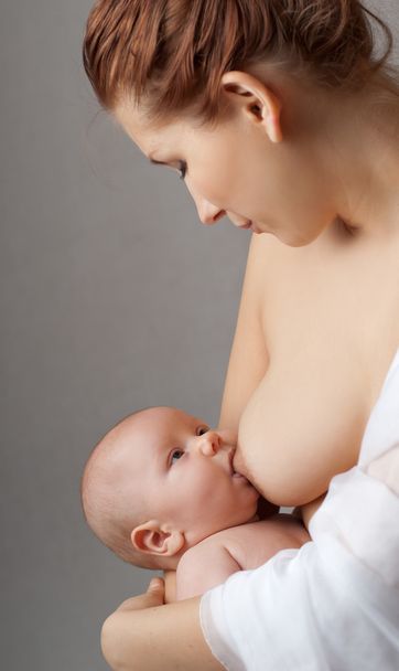Mother breast feeding her infant - Фото, зображення