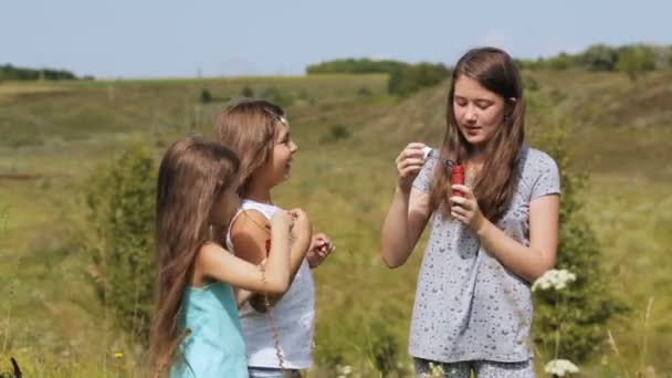 Girls in park blowing bubbles with bubble wand - Footage, Video
