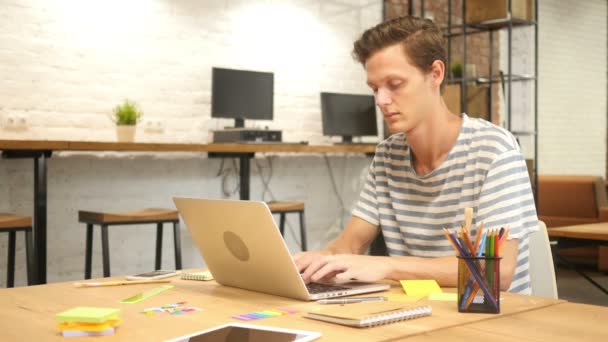 Człowiek, wpisując na klawiaturze laptopa w biurze nowoczesny Loft - Materiał filmowy, wideo