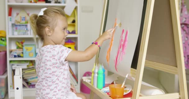 μικρό ξανθό κορίτσι ζωγραφική με νερομπογιές - Πλάνα, βίντεο