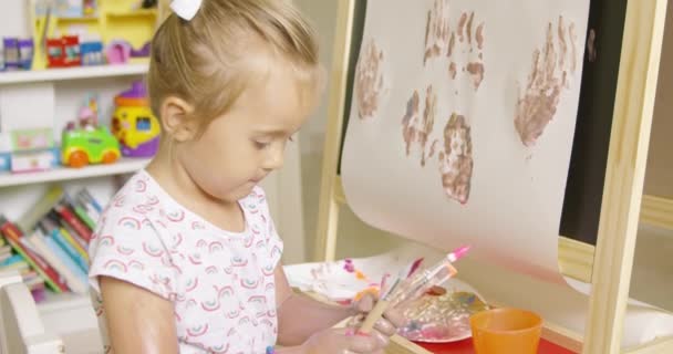 little girl choosing paint brush - Footage, Video