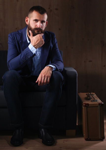 Businessman sitting the sofa in office lobby, isolated on dark background - Fotografie, Obrázek
