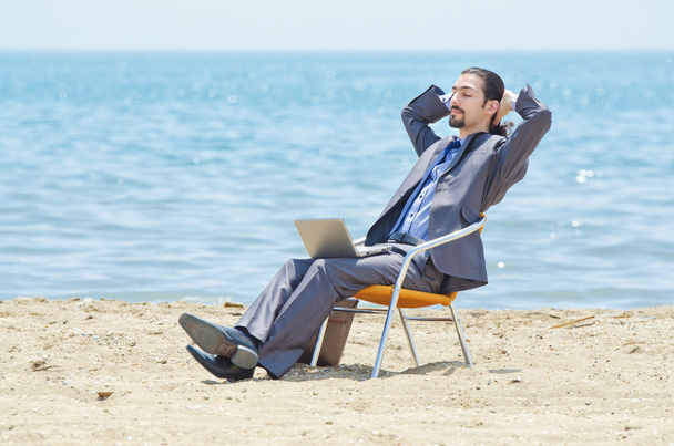 Бизнесмен, работающий над ноутбуком на берегу моря
 - Фото, изображение