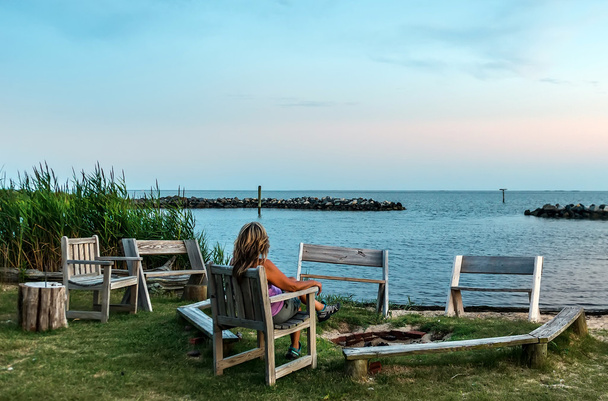 Femme regardant un coucher de soleil sur une plage de Chesapeake Bay
 - Photo, image