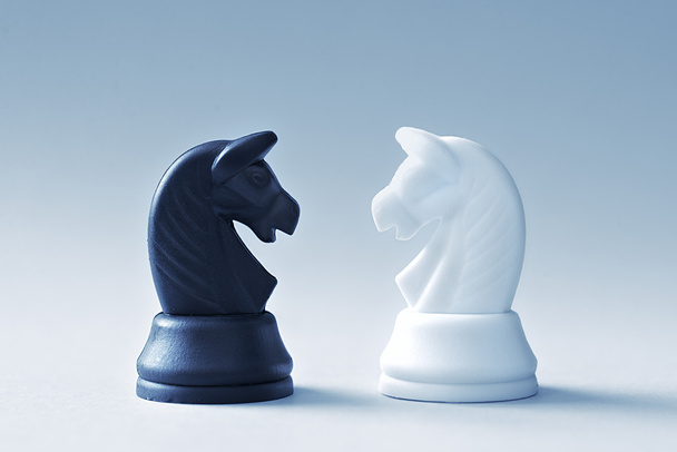 明るい青の背景にチェス騎士の 2 つ - 写真・画像