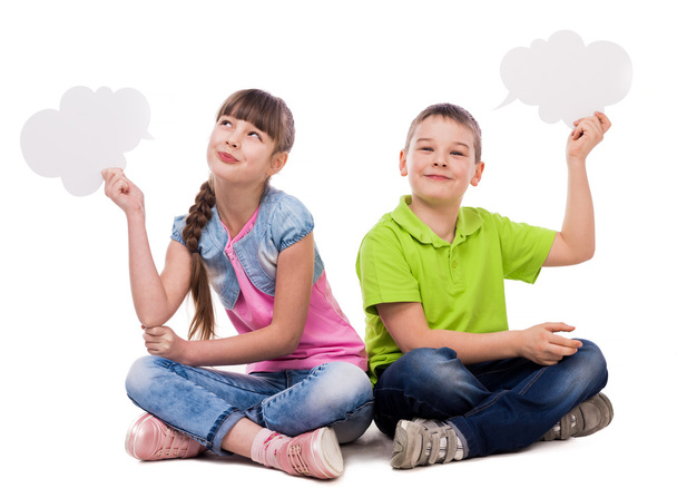 due bambini divertenti seduti sul pavimento con le nuvole di carta in mano
 - Foto, immagini