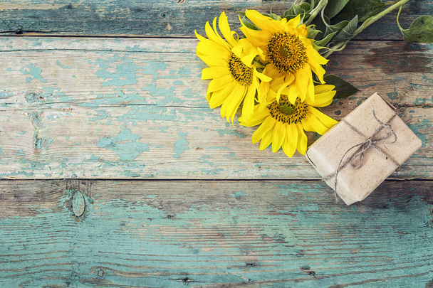Background with sunflowers and gift box on old wooden boards wit - Foto, Bild