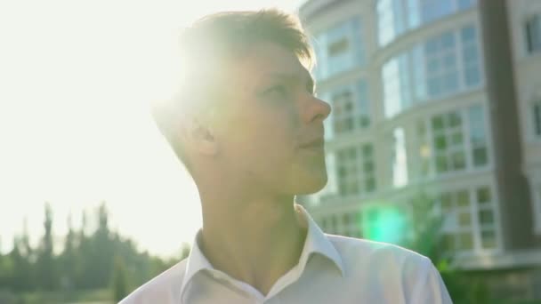 Video portrait of young teenage boy outdoor on the city street slow motion - Záběry, video