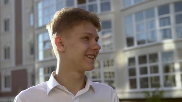 Video portrait of young teenage boy outdoor on the city street slow motion - Felvétel, videó