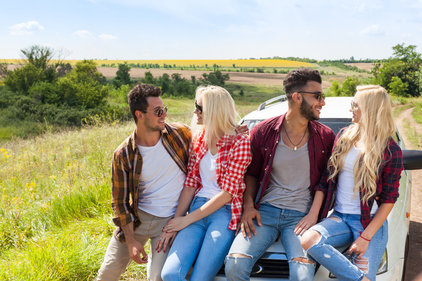 Friends sitting on car outdoor countryside people smile - Foto, Imagen
