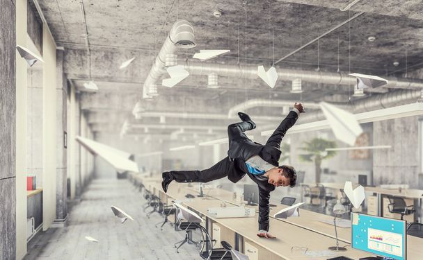Jumping businessman in office . Mixed media - Fotó, kép
