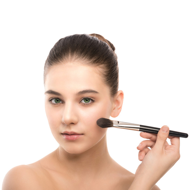 Young brunette woman with clean face. Girl perfect skin applying cosmetic brush. Isolated on a white. - Zdjęcie, obraz