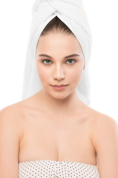 Mooie jonge brunette vrouw met schoon gezicht en handdoek op haar hoofd. Geïsoleerd. - Foto, afbeelding