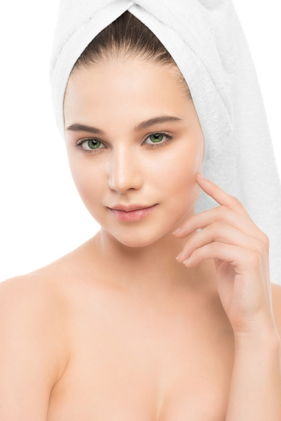 Beautiful young brunette woman with clean face and towel on her head. Isolated. - Foto, imagen