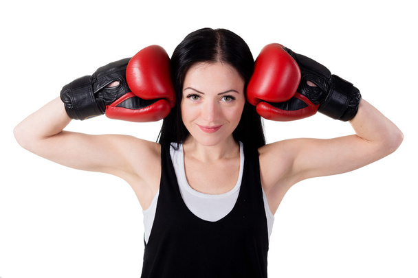 Portrait of a smiling young brunette girl with red boxing gloves - Photo, Image