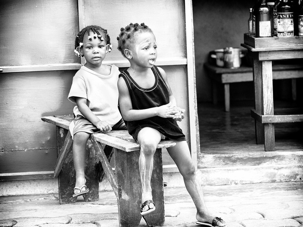 Two little Benin girls sit together on a bench - Foto, afbeelding
