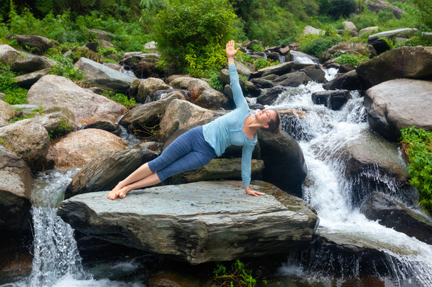 Femme faisant du yoga asana Vasisthasana - pose de planche latérale à l'extérieur - Photo, image