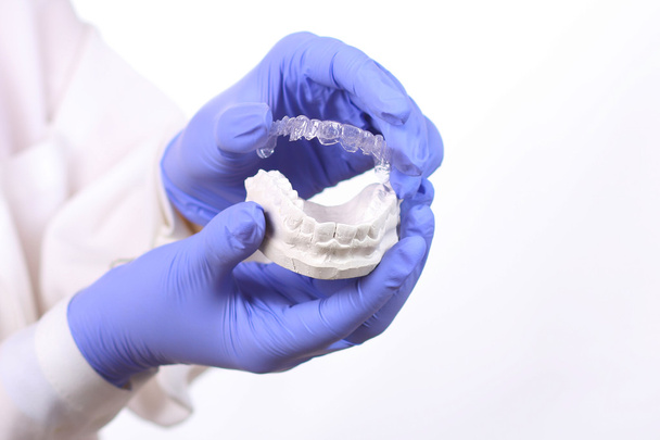 Primo piano di medici mani in guanti che tengono il paradenti in silicone. Cura dei denti
 - Foto, immagini