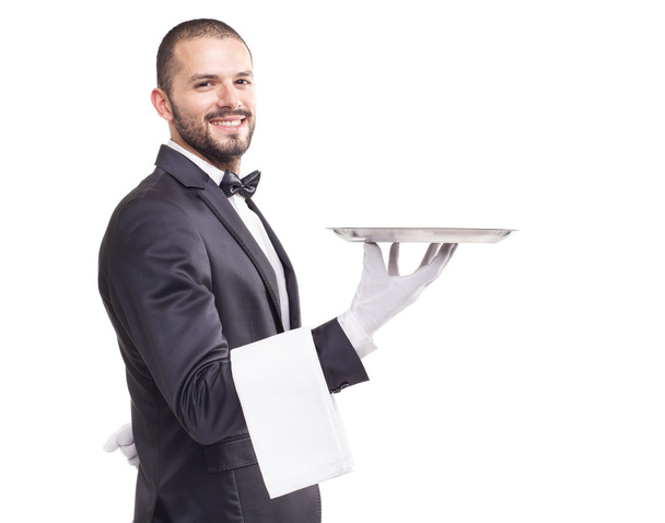 Handsome smiling waiter holding a silver tray - Foto, Imagem