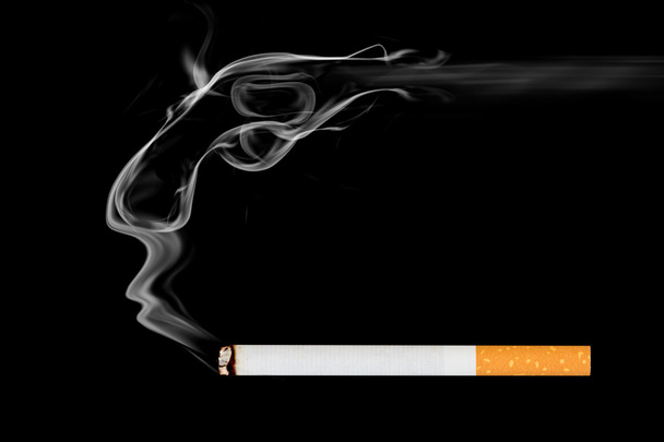 курить сигарету на черном фоне. - Фото, изображение