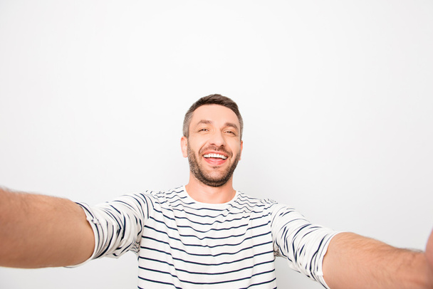 Handsome smiling happy man making selfie on white background - Foto, afbeelding