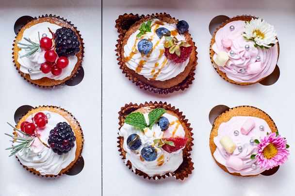 6 heerlijke kleurrijke cupcakes in vak. Traktaties voor de vakantie. - Foto, afbeelding