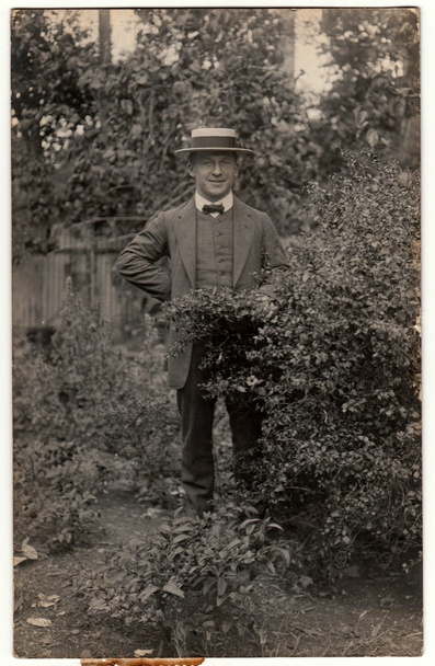 Ein altes Foto zeigt einen Mann mit Strohhut. Retro Schwarz-Weiß-Fotografie. - Foto, Bild