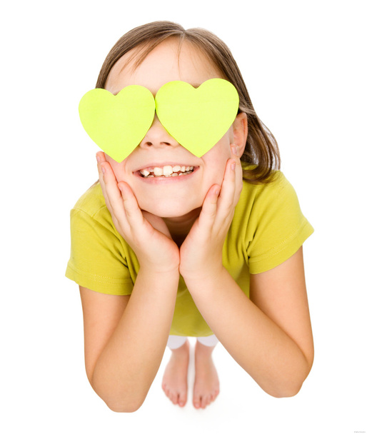 Little girl is holding hearts over her eyes - Foto, imagen