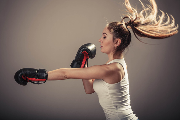 Energetic young woman fight with boxing gloves. - Foto, afbeelding