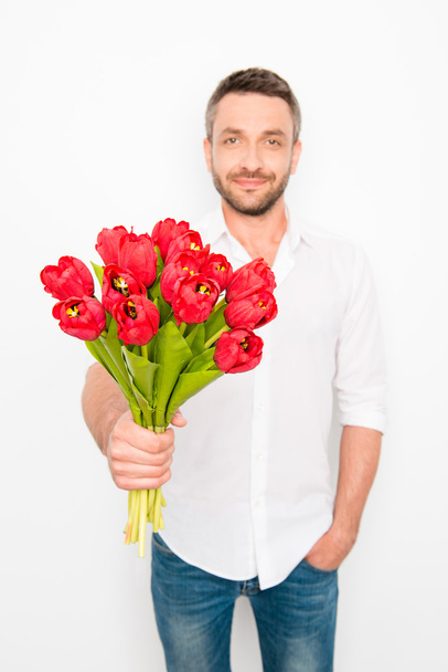 Портрет красивого хлопця, що тримає букет червоних тюльпанів
 - Фото, зображення
