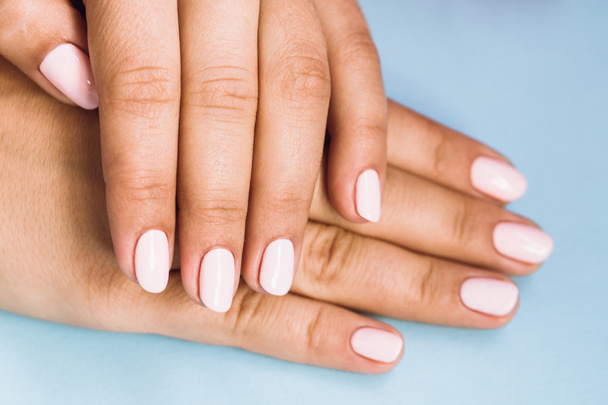 Mooie vrouw met mooie roze manicure nagels - Foto, afbeelding