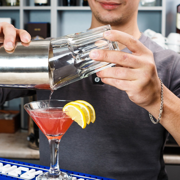 Mani di barman che mescolano cocktail cosmopolita
 - Foto, immagini