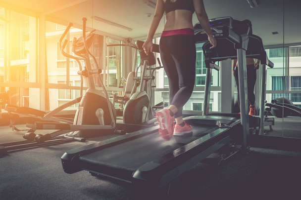 Mujer corriendo en un gimnasio en un concepto de cinta de correr para hacer ejercicio
,  - Foto, imagen