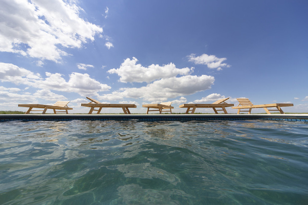 Vue imprenable sur la piscine avec chaises longues en bois
. - Photo, image