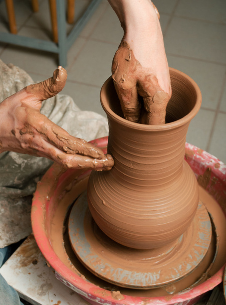 Hands of a potter, creating an earthen jar on the circle - Photo, image
