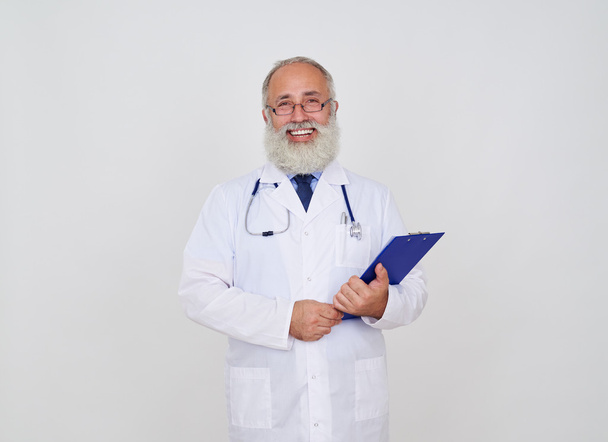 Smiling male doctor with a folder and stethoscope in uniform  - Fotó, kép
