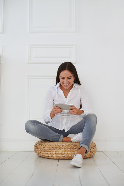 Jeune femme d'affaires assise avec la jambe croisée et tenant la tablette
  - Photo, image