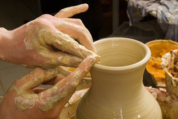 Hände eines Töpfers, der ein irdenes Gefäß aus weißer Tonerde herstellt - Foto, Bild