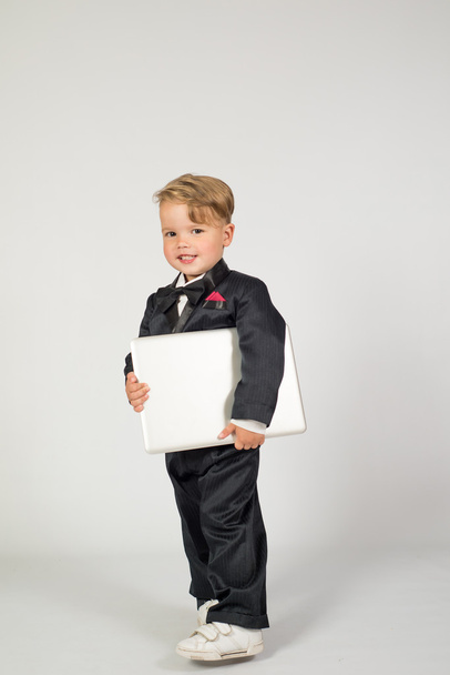 a child in the role of office manager with laptop and phone - Foto, imagen