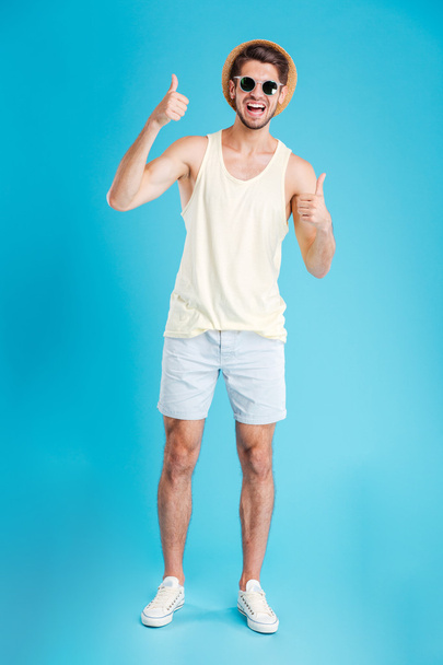 Cheerful young man showing thumbs up with both hands - Фото, зображення