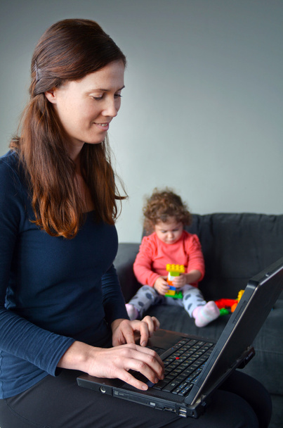 Happy mother with baby toddler works from home - Photo, Image