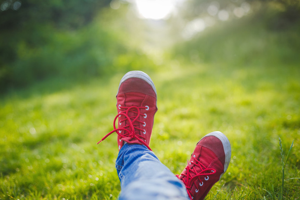 çim üzerinde yalan spor ayakkabı kız - Fotoğraf, Görsel