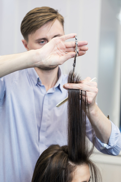 Hairdresser making a haircut for a brunette girl - Foto, Imagen