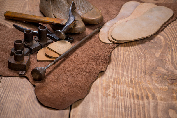 Ensemble d'outils artisanaux en cuir sur fond en bois. Lieu de travail pour cordonnier
. - Photo, image
